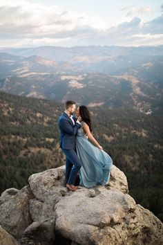 a man and woman standing on top of a mountain