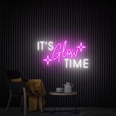 it's glow time neon sign on the wall next to a chair and table