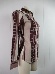 "Vintage 1970s women's disco shirt, mod blouse. Made of polyester. Color is burgundy and white. Has button down front and button cuffs. Made by Stitches. About a size medium. Actual measurements are: 35\" around the bust 30\" around the waist 14\" shoulder seam to shoulder seam 22.5\" shoulder seam to end of cuff 27\" overall length In very good condition." Fitted Brown Shirt, Fitted Long Sleeve Shirt With Retro Print, Retro Button-up Fitted Blouse, Retro Fitted Button-up Blouse, Fitted Retro Print 70s Inspired Tops, Fall Retro Print Button-up Blouse, Collared Retro Print Tops For Fall, Fitted Shirt With Retro Print For Fall, Fitted Cotton Blouse With Retro Print