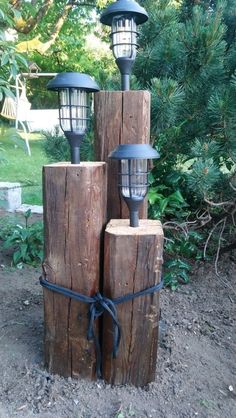 three wooden posts with lights tied to them