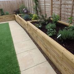 a garden with artificial grass and wooden fence