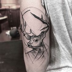 a man with a deer head tattoo on his arm