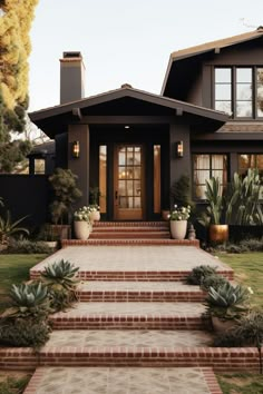 a house with steps leading up to the front door and plants in pots on either side