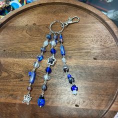 a blue and white beaded necklace on a wooden table next to other jewelry items