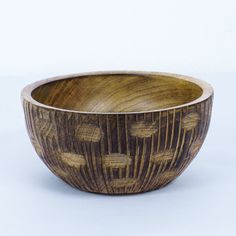 a wooden bowl sitting on top of a white table