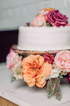 two tiered wedding cake with flowers on top