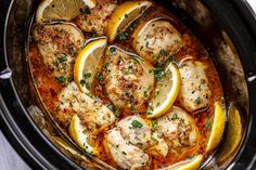 a pan filled with chicken and lemons on top of a table