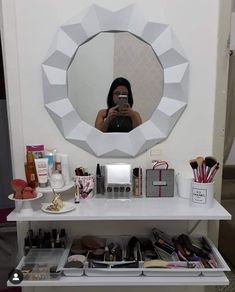 a woman taking a selfie in front of a mirror with makeup and cosmetics on it