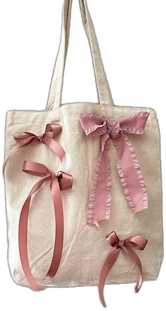 two bags with pink bows on them and one has a bow at the bottom,