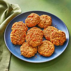 a blue plate topped with carrot patties on top of a green cloth covered table