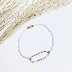 An elongated oval is forged by hand and accented with textured sterling silver chains, creating a simple and beautiful everyday bracelet. From our Geo Labradorite Collection. #eclectic #mixedmetals #handcraftedjewelry •14k gold filled with sterling silver chain •Shape Dimensions: about 1 x .25" •Length: 7.25" Elongated Oval, Everyday Bracelet, Silver Chains