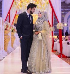 a man and woman standing next to each other in front of a wedding ceremony stage