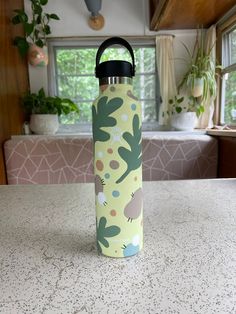 a water bottle sitting on top of a counter next to a potted plant in a kitchen