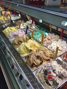 a display case filled with lots of different flavored ice creams and desserts