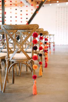 a row of chairs with tassels on them and one chair in the middle