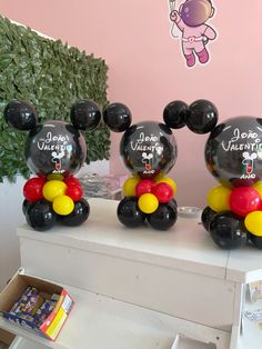 three mickey mouse balloons sitting on top of a table