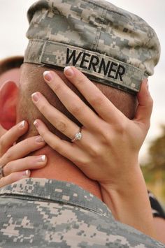 a woman covering her face behind a man's head