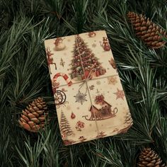 a wrapping paper with a christmas tree on it is tied to a pine tree branch