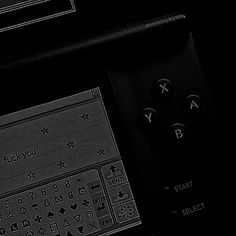 two remote controls sitting next to each other on top of a black surface with white writing