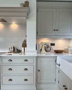 a kitchen with gray cabinets and white counter tops is pictured in this image from the front view