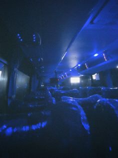 the interior of an airplane is lit up with blue lights and people are sitting in seats