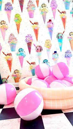 an inflatable pool with ice cream cones and beach balls on the floor next to it