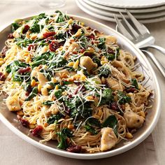 a white plate topped with pasta and spinach