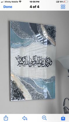 an arabic calligraphy is displayed on the wall above a sink and faucet