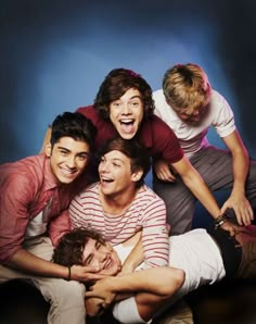 four young men are posing for a photo together, one is holding his head in the other's arms