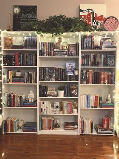 a bookshelf filled with lots of books on top of a hard wood floor