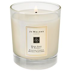 a candle that is sitting on top of a white tablecloth with the words jo malone written