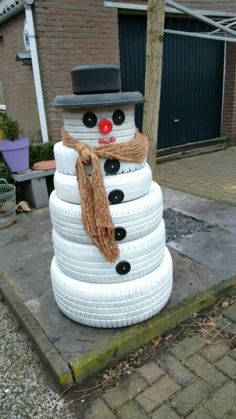 a snowman made out of tires on the sidewalk