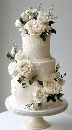 a wedding cake with white flowers and greenery