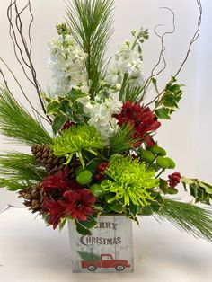 a christmas flower arrangement in a metal container