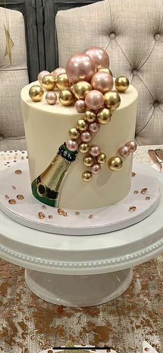 a cake decorated with pearls and a bottle of champagne