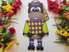 a paper cutout of a monkey wearing a sweater surrounded by colorful flowers and greenery