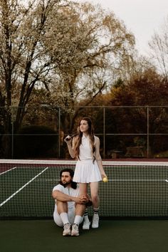 two tennis players pose for a photo on the court