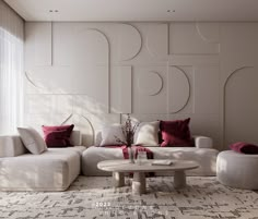 a living room with white couches and red pillows on the walls, along with a round coffee table