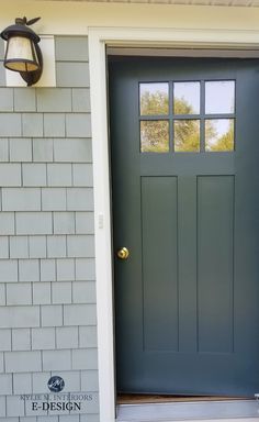 a gray front door with two windows and a light on the side of the house