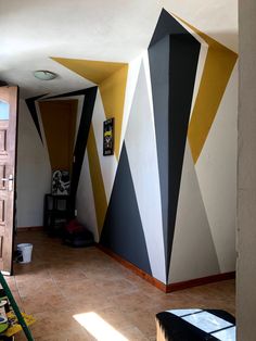 a room that has been painted with different colors and shapes on the walls, along with other items