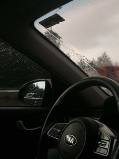 the dashboard of a car with rain on it