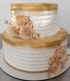 there is a three layer cake with gold flowers on the top and bottom tiers