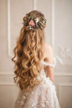 the back of a woman's head with long hair and flowers in her hair