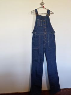 "Vintage Frederick's of Hollywood 1970's Overalls, 100% Cotton- No- Stretch, Adjustable Shoulder Straps Zipper Front, Two Setting Button Flaps at Waist,  Mint Vintage Condition, Never Worn or  Washed, Tag Reads L 31, Flat Measurements: Waist 32\" 1st.Button , 2nd Button 28\" 9 Front Buttons, Inseam 34\", 22\" Top Of Bid to Crotch, 34\" Hips, 8\" Wide Bottom Leg  Shoulder Strap Length 16\" to 29\" Very Cute. (909)" Retro High Rise Jeans For Workwear, Retro Fall Jeans With Button Closure, Vintage Jeans For Fall, Retro Denim Jeans For Workwear, Vintage Pre-washed Fall Jeans, Vintage Spring Workwear Jeans, Retro Medium Wash Jeans With Buttons, Vintage Fitted Jeans With Button Closure, Vintage Medium Wash Bottoms For Work