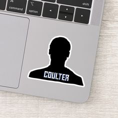 a laptop computer sitting on top of a wooden table next to a sticker that says collier