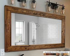 a bathroom mirror sitting above a sink under a faucet mounted on a wall