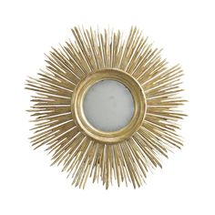 a gold sunburst mirror on a white wall