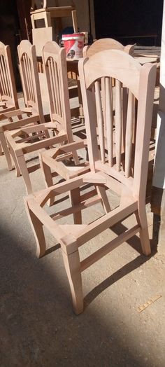 several wooden chairs are lined up on the ground