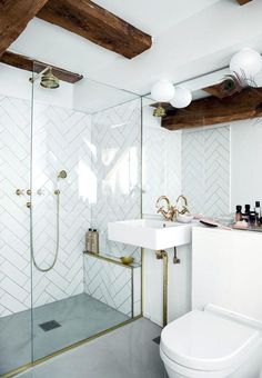 a bathroom with a white toilet sitting next to a walk in shower and a sink