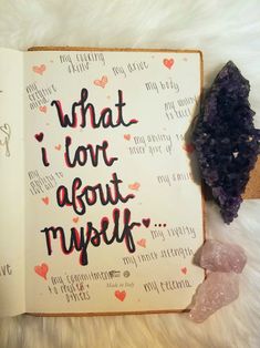 an open book with the words what i love about my life written on it next to some crystals